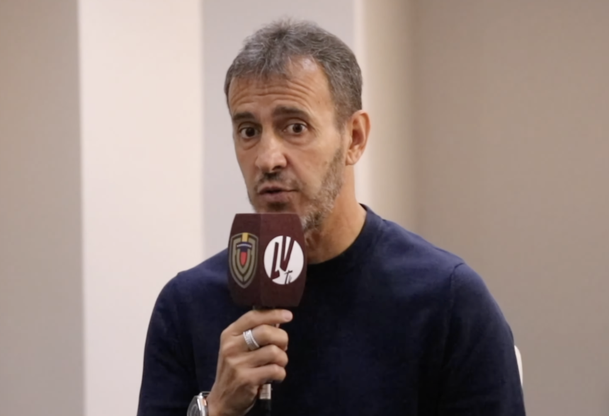 Fernando "Bocha" Batista tiene un suéter azul oscuro con un micrófono en la mano perteneciente a la Vinotinto TV